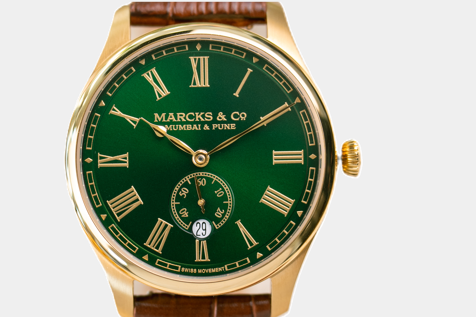Gold watch with green face and brown leather strap on a white background